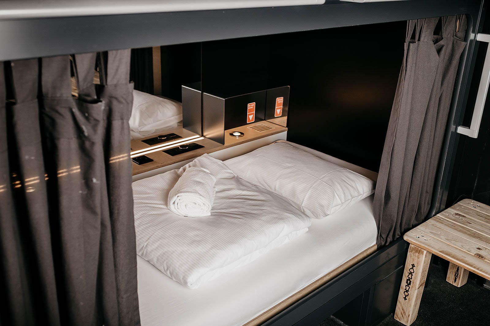 Row of compact sleeping berths along a lit corridor