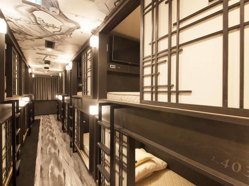 Compact sleeping cabins stacked along a lit interior corridor