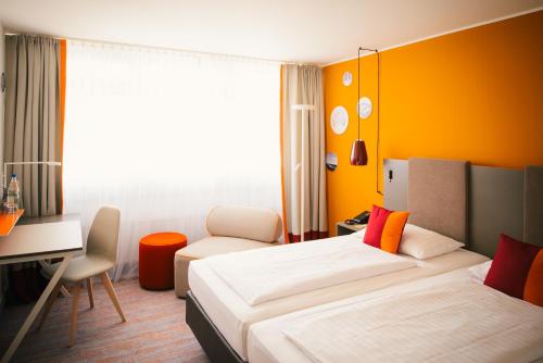 Compact hotel room with a bed, a small desk and a window